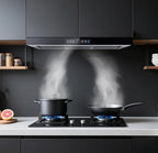 A modern black range hood installed under dark charcoal kitchen cabinets, shown with two lit gas stovetops and steaming pots and a pan in a real kitchen setting.