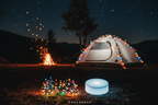 Multicolour LED fairy string lights next to white round camping hub unit, glowing tent campsite at night, no logo or icons